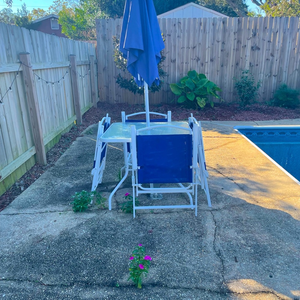 Outdoor table, 4 chairs and umbrella! glass top with white metal frame.